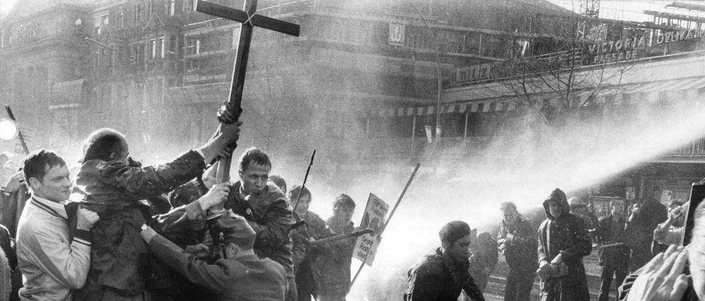 Demonstranten mit Kreuzen im Strahl der Wasserwerfer. Der 14. April 1968 auf dem Kurfürstendamm.
