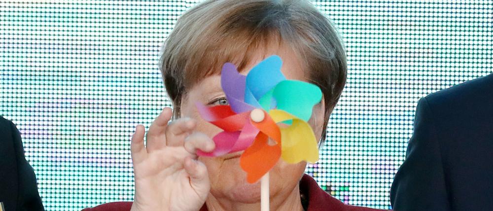 Bundeskanzlerin Angela Merkel mit einem bunten Windrad auf der Bühne.
