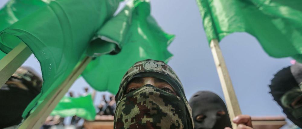 Maskierte Anhänger der palästinensischen islamistischen Hamas-Bewegung schwenken Fahnen bei einer Demonstration.