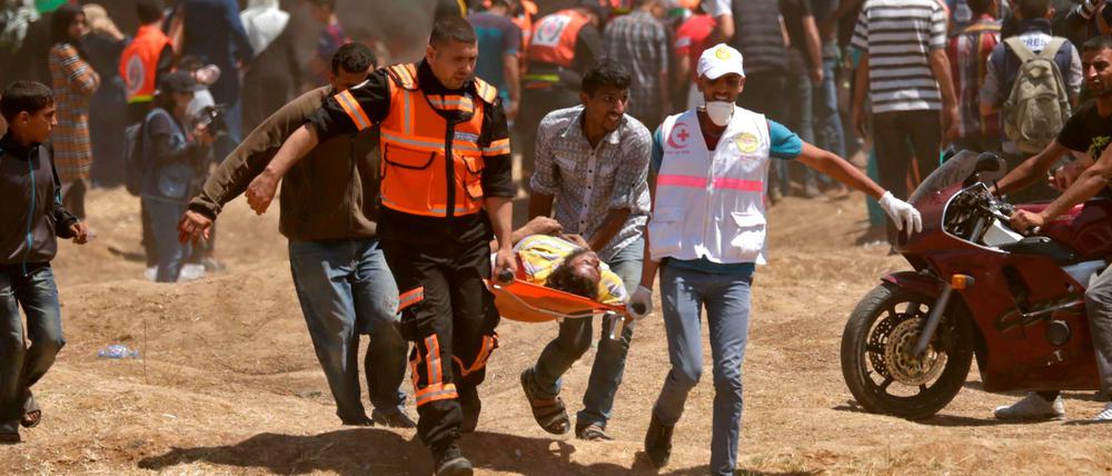 Palästinenser bergen einen verletzten Demonstranten.