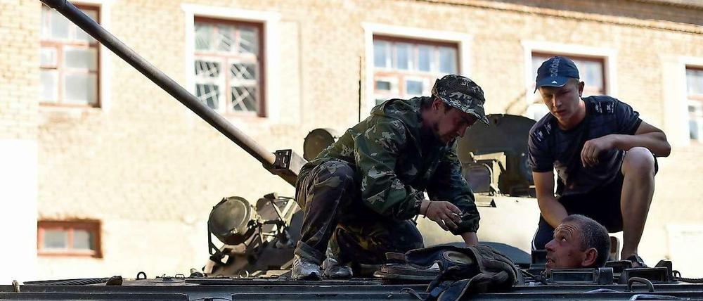 Pro-russische Separatisten versuchen im Süden von Donezk einen Panzer zu reparieren.