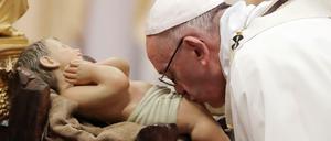 Papst Franziskus küsst am 24.12.2017 bei der Weihnachtsmesse im Petersdom im Vatikan das Christuskind.