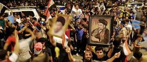 Anhänger des schiitischen Geistlichen al-Sadr jubeln in Bagdad nach ersten Hochrechnungen zur Parlamentswahl.