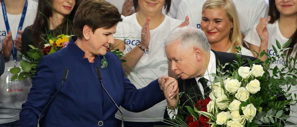 Jaroslaw Kaczynski küsst die Hand der Wahlsiegerin Beata Szydlo. 