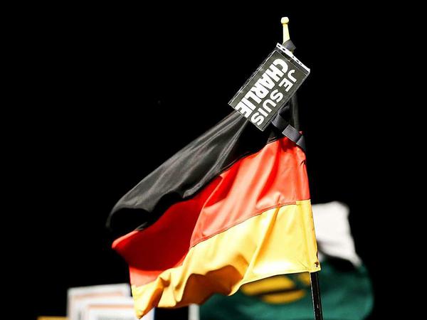 Bei der "Pegida"-Demonstration in Dresden sind erneut viele schwarz-rot-goldene Flaggen zu sehen – und auch einige "Je Suis Charlie"-Plakate.