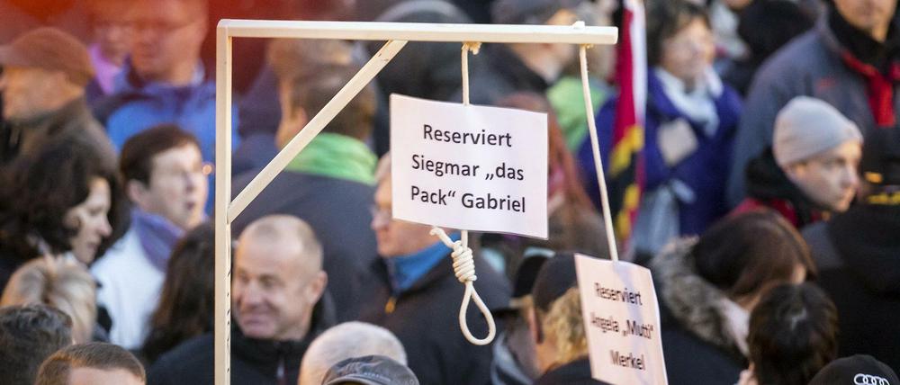 Pegida-Demonstranten zeigen Galgen für "Siegmar [sic] Gabriel" und "Angela "Mutti" Merkel.