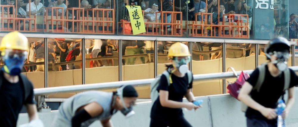 Gäste eines Restaurants in Hongkong beobachten Straßenproteste.