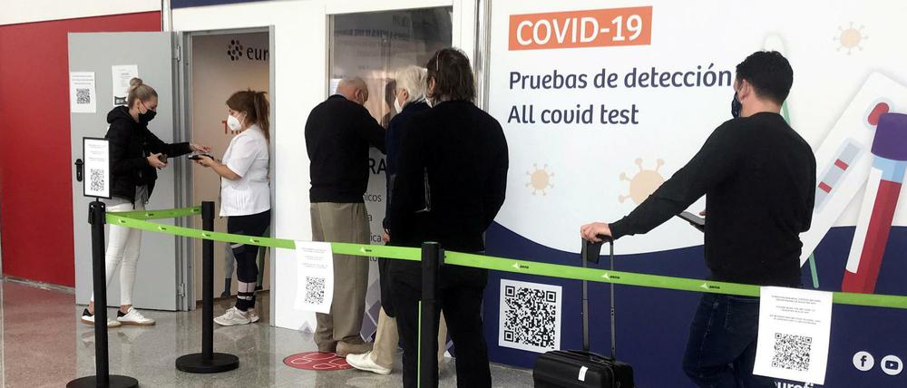 Reisende warten vor einem Testzentrum am Flughafen von Palma des Mallorca.