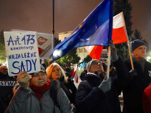 Demonstranten schwenken Fahnen vor dem polnischen Parlament in Warschau und protestieren gegen die Justizreform. 