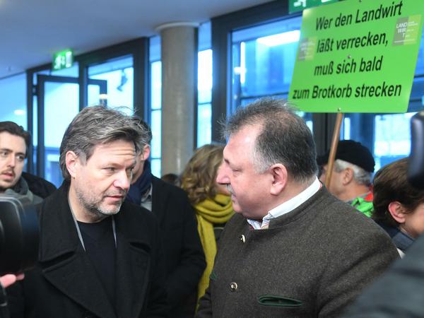 Grünen-Chef Robert Habeck (l.) spricht beim Politischen Aschermittwoch der Grünen mit protestierenden Bauern.
