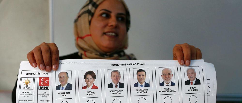 Eine Wahlhelferin hält einen Stimmzettel, auf dem die Kandidaten für die Präsidentenwahl aufgelistet sind. 