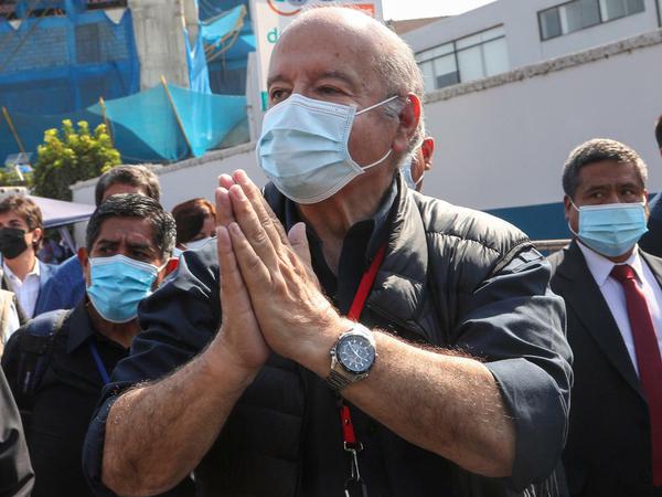 Hernando De Soto, Präsidentschaftskandidat der Partei Avanza Pais, trägt eine Maske und betet neben seinen Unterstützern bei seiner Ankunft zur Stimmabgabe.