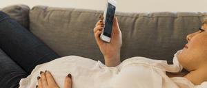Eine schwangere Frau nutzt ihr Smartphone - ist das bereits gefährlich? 
