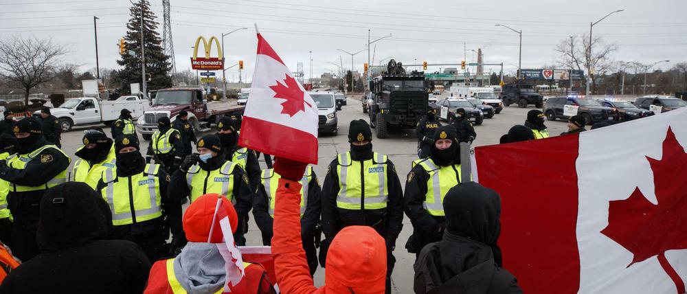 Demonstranten blockieren die „Ambassador Bridge“ und sehen sich einer geschlossenen Reihe der kanadischen Polizei gegenüber.