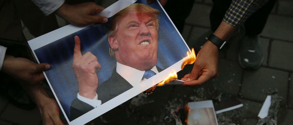 Iranische Demonstranten verbrennen in Teheran ein Bild des US-amerikanischen Präsidenten Trump vor der früheren US-Botschaft.
