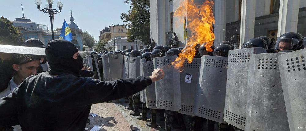 Ukrainische Demonstranten bedrohen die Nationalgarde, die das Parlament zu schützen versucht. 