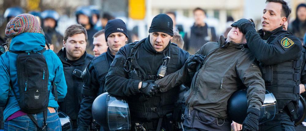 Polizisten führen in der Innenstadt während des Protests gegen einen Aufzug von Neonazis einen Gegendemonstranten ab.