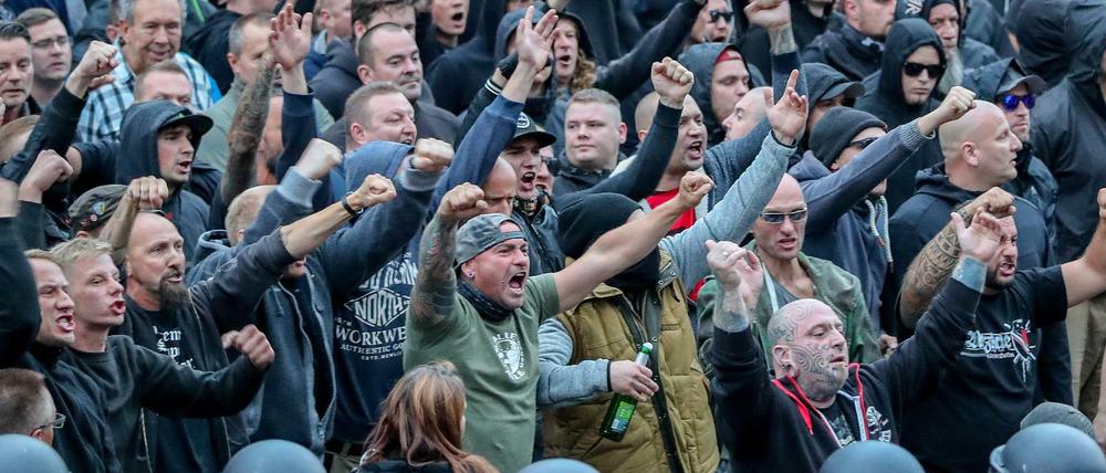  27.08.2018, Sachsen, Chemnitz: Demonstranten aus der rechten Szene gestikulieren und drohen Gegendemonstranten Gewalt an. 
