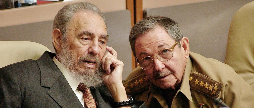 Der damalige kubanische Präsident Fidel Castro (l) spricht mit seinem Bruder Raul Castro (r). 