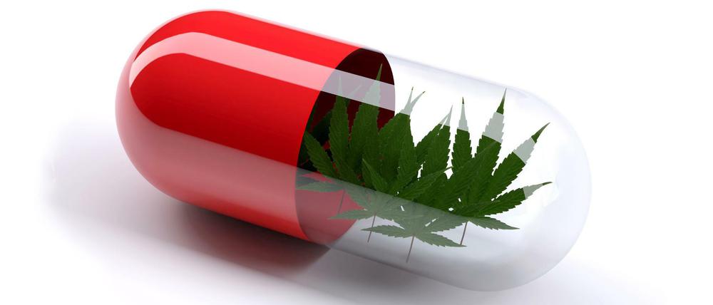 Eine rote Pille gefüllt mit Marihuana-Blättern. (Symbolbild)