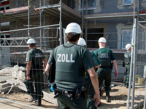 Zollbeamte betreten bei einer Razzia gegen Schwarzarbeit im Juni 2014 eine Baustelle in Frankfurt am Main.