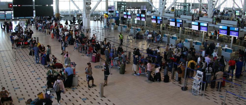 Reisende in Kapstadt warten auf ihren Rückflug. Wie viele von ihnen verbreiten die neue Omikron-Variante?