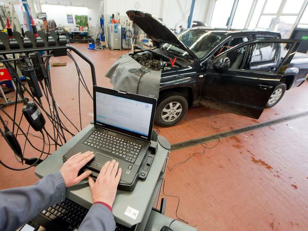 Ein Kfz-Meister lädt im Rahmen der Rückrufaktion ein Software-Update für das Steuergerät Motorelektronik auf einen Volkswagen.
