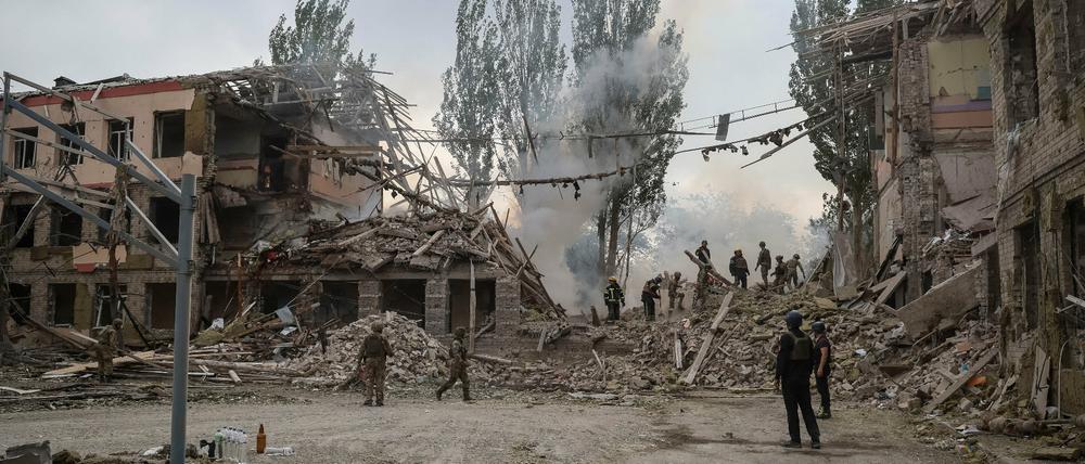 Aufbauarbeiter räumen Ruinen einer zerstörten Schule in Kramatorsk auf.
