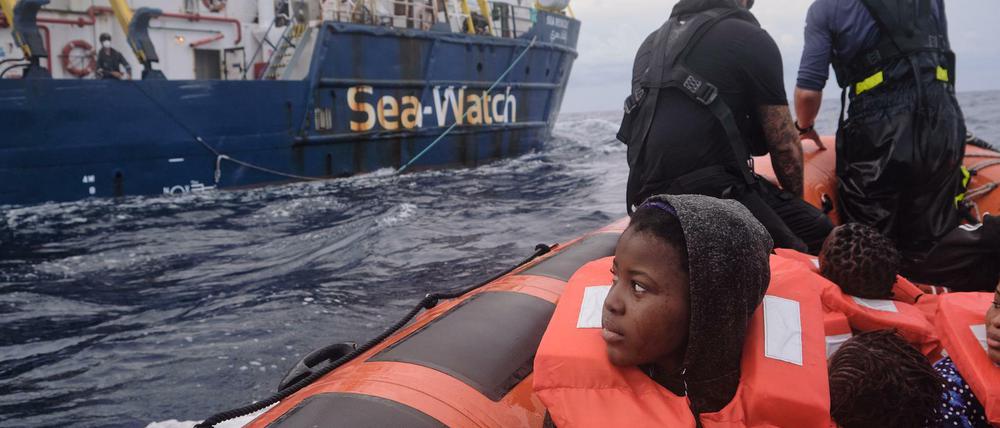 Ein Rettungsboot bringt gerettete Menschen zur Sea-Watch 3.