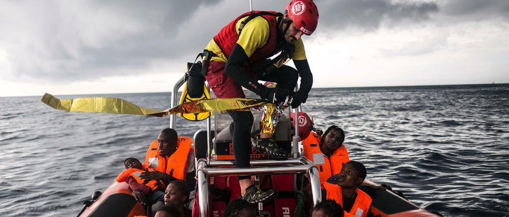 Ein Helfer öffnet eine Rettungsdecke für Flüchtlinge, die auf dem Mittelmeer gerettet wurden.