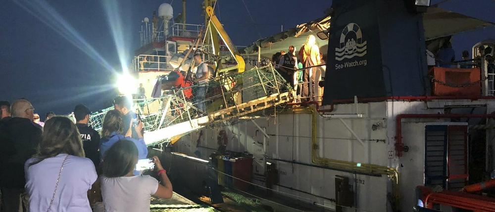 Menschen steigen von Bord des Rettungsschiffs "Sea-Watch 3" nach dem Anlegen im Hafen der Insel Lampedusa.