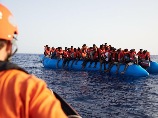 Seenotretter der Organisation Sea-Eye und Flüchtlingsboot im Mittelmeer. 