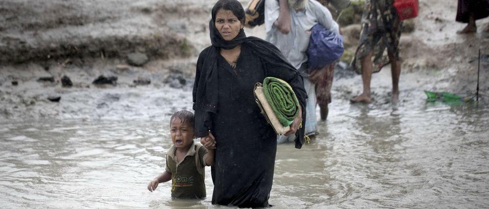 Angehörige der Rohingya flüchten mit ihren wenige Habseligkeiten nach Bangladesch.