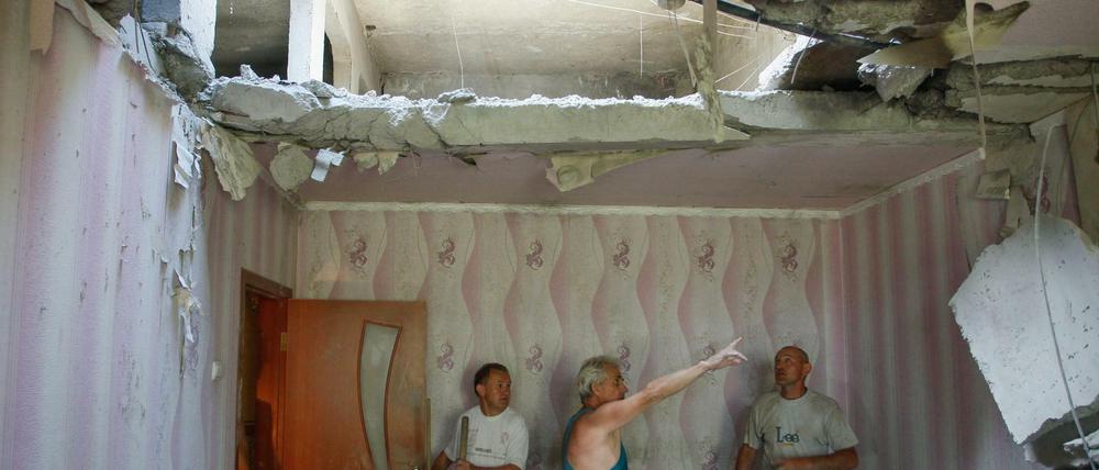 Juni 2016: Männer schauen auf ein Loch in einem Wohnhaus im ostukrainischen Donezk.