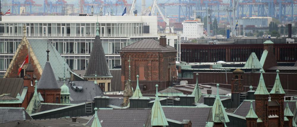 Blick auf die Dächer der Hamburger Speicherstadt (vorne) und die Kräne der Containerterminals 