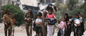 Ein Soldat des Rebellenbündnisses begleitet Zivilisten in der Nähe von Aleppo.