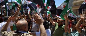 Syrer schwingen auf einer Kundgebung in Azaz oppositionelle Flaggen, um die türkische Drohung einer Militäroffensive in Nordsyrien zu unterstützen.