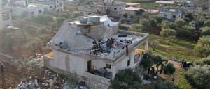 Menschen versammeln sich nach dem US-Angriff in einer syrischen Stadt an einem zerstörten Haus.