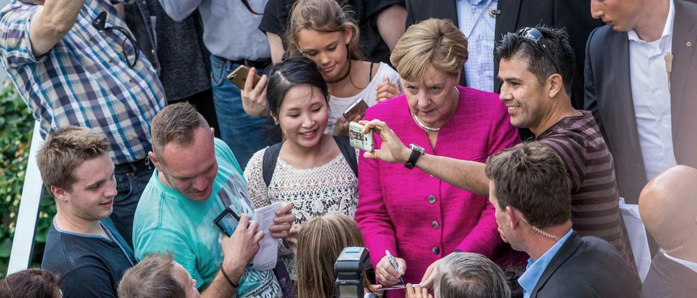 Bundeskanzlerin Angela Merkel (CDU) begrüßt Besucher beim Tag der Offenen Tür der Bundesregierung.
