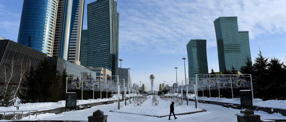 Ein Mann läuft in Astana. Der Bajterek-Turm ragt im Hintergrund empor. (Archivbild)