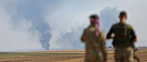 Von der Türkei unterstützte syrische Milizen blicken auf Rauch, der während der Kämpfe am 30.10.2019 etwa 15 Kilometer nördlich von Ras-al-Ain aufsteigt.
