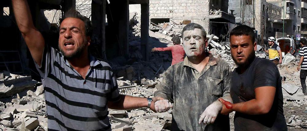 Verletzte Männer nach einem Luftangriff auf einen Markt in der syrischen Stadt Maaret al-Numan.