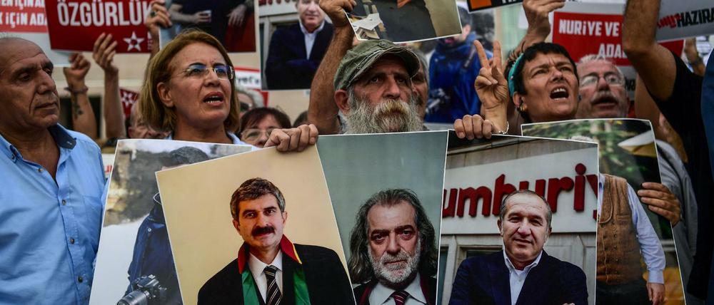 Demonstranten halten Fotos inhaftierter Journalisten hoch. Gegen diese hat Hüseyin Gülerce als Zeuge ausgesagt.