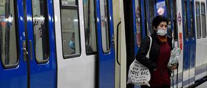 Eine Frau mit Maske steigt an der Atocha Station in Madrid aus dem Zug. Das Land fährt schrittweise seine Wirtschaft wieder hoch.