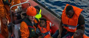 Mitglieder der deutschen Organisation Sea-Eye bringen Migranten zum Rettungsschiff "Alan Kurdi".