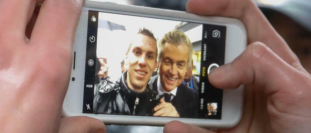 Ein junger Mann nimmt ein Selfie mit dem Rechtspopulisten Geert Wilders auf.