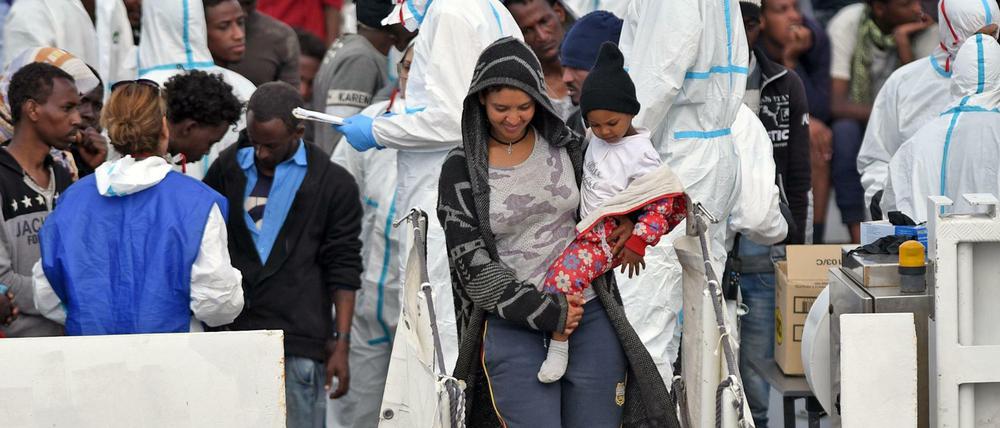 Ankunft in der EU. Eine Frau verlässt mit einem Kind in Sizilien ein Boot der italienischen Küstenwache.