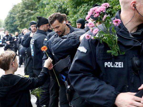 Ein kleiner Junge bedankt sich am Samstag bei Polizisten mit Blumen.