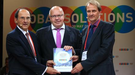 Gastgeber Dennis Snower (l.) und Dirk Messner (r.) übergeben die Empfehlungen der Thinktanks für die G20-Staaten an Kanzleramtschef Peter Altmaier (CDU).