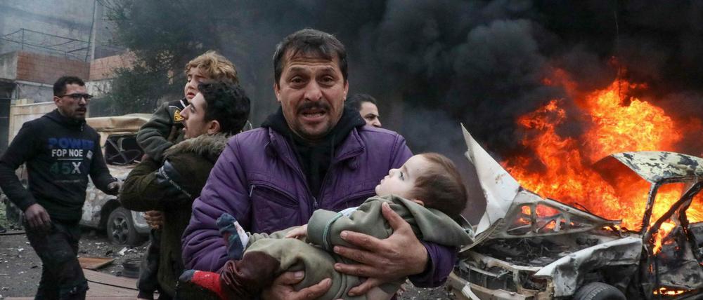 Ein Mann trägt sein Kind in Aleppo in Syrien.